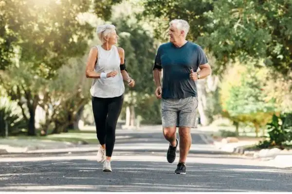 Couple de seniors marchant rapidement ensemble dans un parc pour maigrir après 50 ans