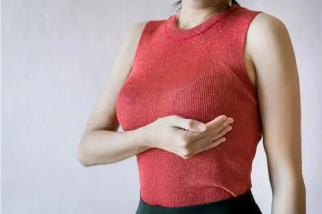 Femme tenant sa poitrine, illustrant une transformation de la taille du volume mammaire