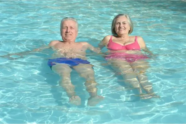 Homme et femme seniors se relaxant dans une piscine pour entretenir leur forme