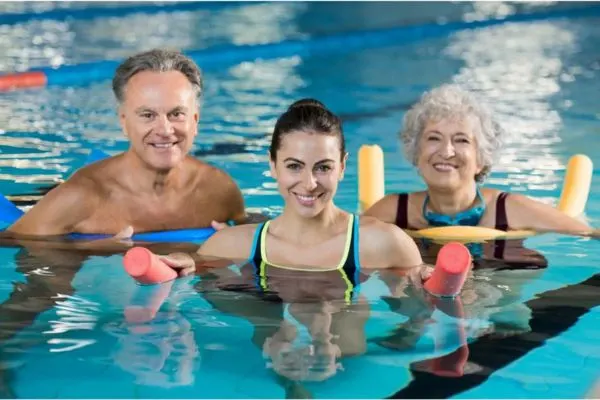 Groupe de seniors faisant des exercices d’aquagym en piscine