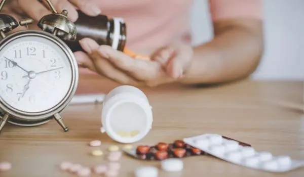 Réveil posé à côté de comprimés et d’un flacon, suggérant une prise de médicaments
et des effets sur le sommeil