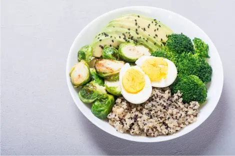 Un repas sain composé de légumes verts, œufs et quinoa