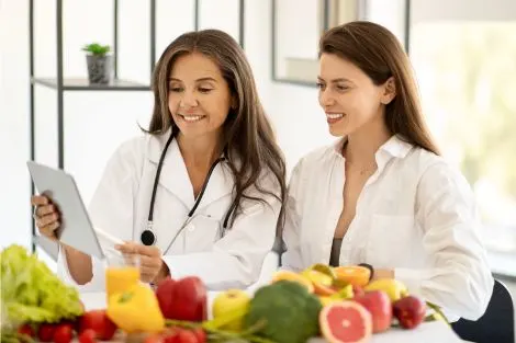 Nutritionniste montrant un menu équilibré à une femme senior souriante