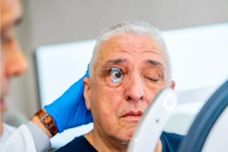 Examen de la vue avec un appareil de dépistage et un praticien à côté