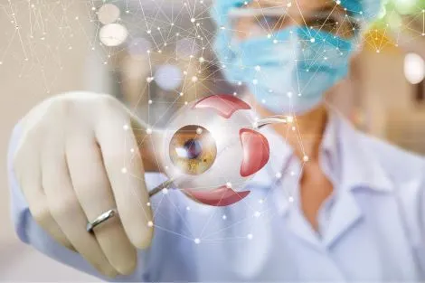 Un professionnel de santé tient un modèle 3D d'un œil humain avec des graphismes numériques