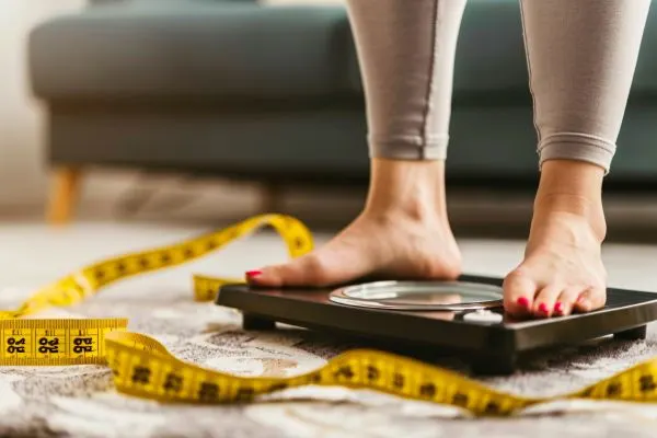 une-femme-debout-sur-une-echelle-avec-un-ruban-a-mesurer-autour-d-elle