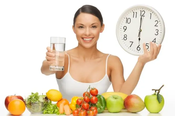 Horloge et aliments légers symbolisants le jeûne intermittent comme alternative au jeûne hydrique strict