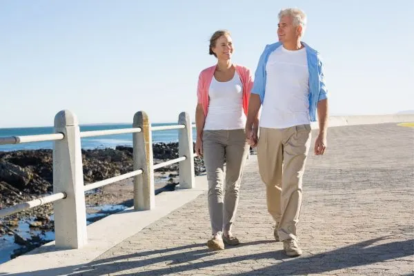 Couple de seniors marchant au bord de mer, image illustrant les bénéfices du jeûne hydrique après 50 ans