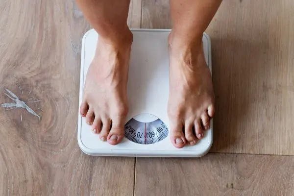 Balance et silhouette d’une personne de plus de 50 ans pour illustrer la perte de poids avec le jeûne hydrique