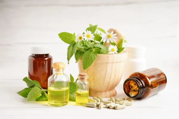 Plantes médicinales disposées à côté de comprimés sur une table, illustrant la différence entre
laxatif naturel doux et laxatif stimulant pour l'intestin