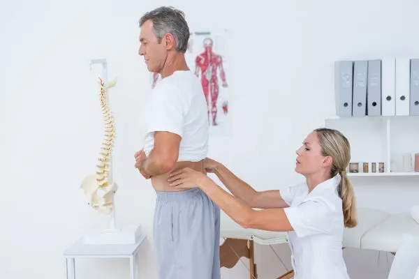 personne de plus de 50 ans consultante un médecin pour une douleur lombaire intense