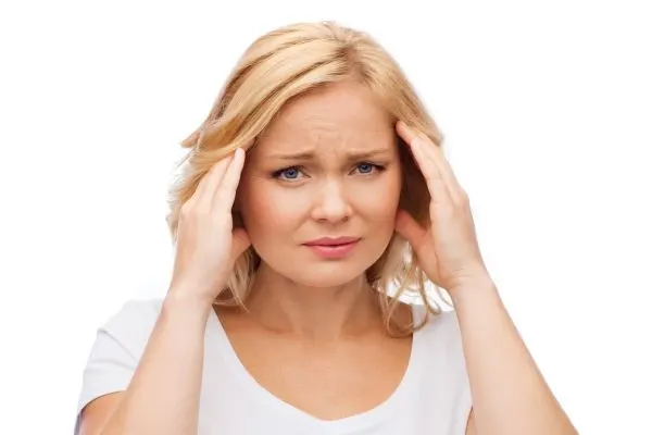 femme de plus de 50 ans anxieuse se tenant la tete pour illustrer le lien entre serotonine et anxiete
