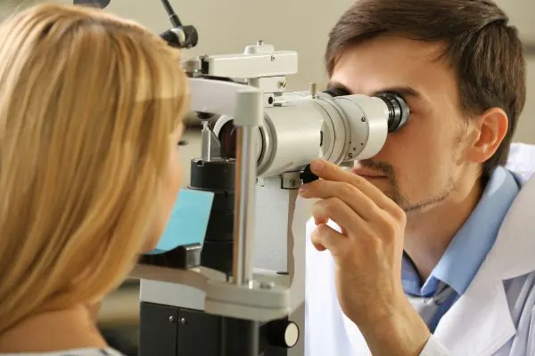 Ophtalmologue examinant les yeux d’un patient senior à la lampe à fente pour suivre les séquelles d’un zona ophtalmique