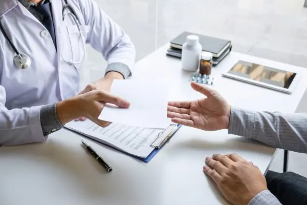 Médecin présentant une ordonnance d’antiviraux à un patient pour traiter un zona ophtalmique