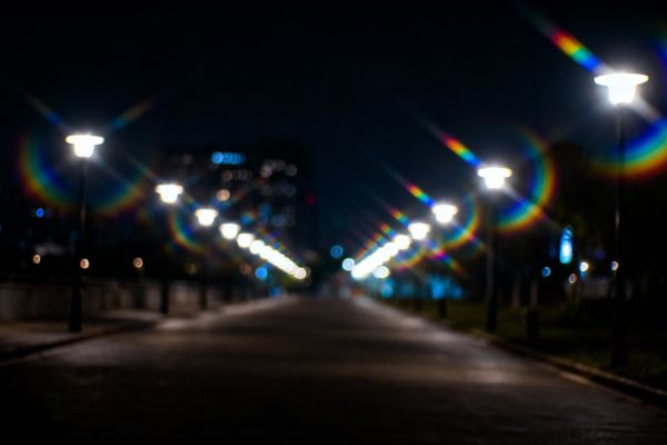 Vue subjective des lumières de la ville la nuit, montrant les symptômes visuels du glaucome : halos irisés autour des lampadaires etun effet de vignette sombre sur les bords (vision tubulaire). Le centre est légèrement flou.