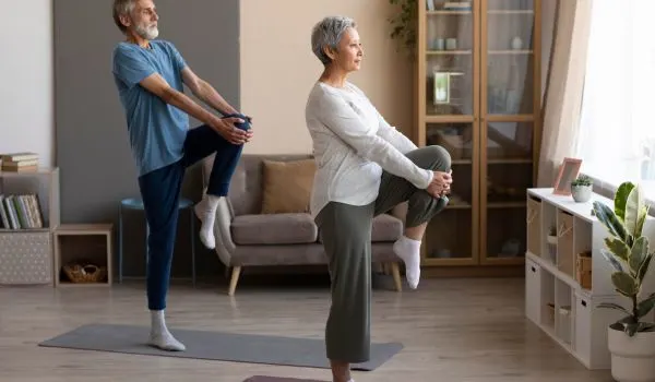 Couple senior pratiquant des étirements doux des jambes pour protéger les articulations et améliorer l'équilibre