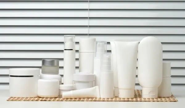 Plusieurs crèmes et flacons alignés, certains à moitié utilisés, rangés de manière désordonnée